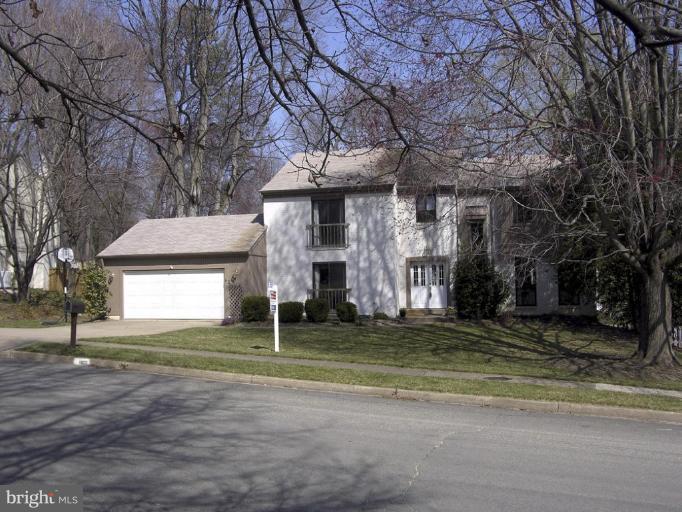 a view of a house with a large tree and a yard