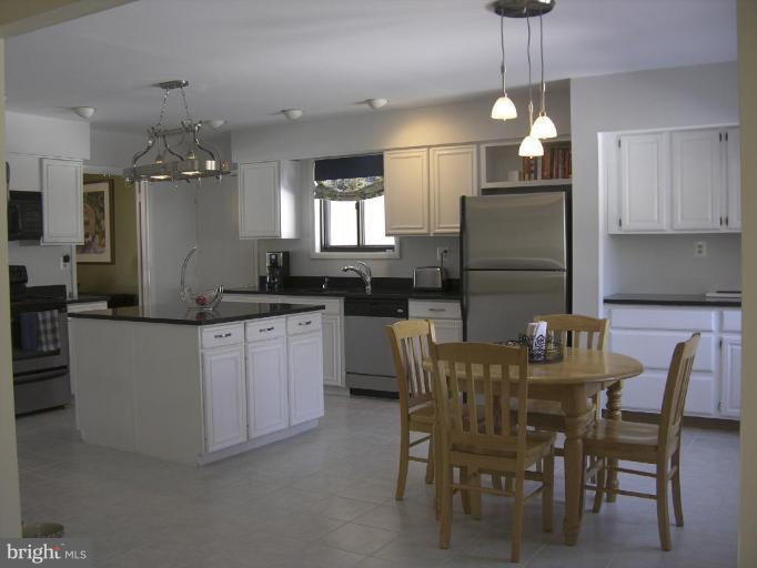 11820 Grey Birch Place Reston, VA 20191 - Photo 3 of 20 a kitchen with kitchen island granite countertop a table and chairs in it