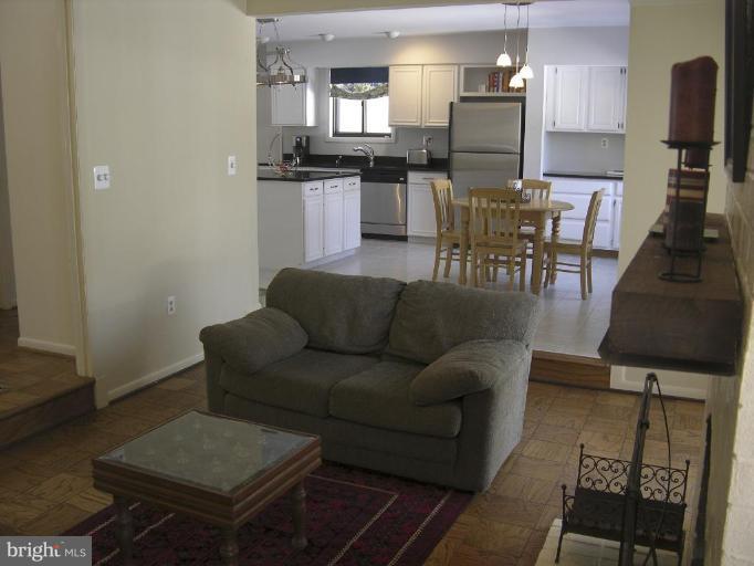 11820 Grey Birch Place Reston, VA 20191 - Photo 4 of 20 a living room with furniture a kitchen view and a dining table