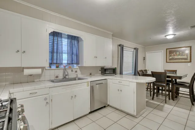 a kitchen with a sink and chairs