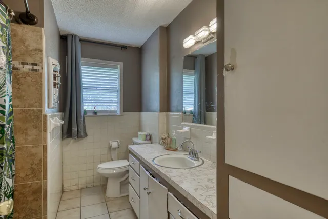 a bathroom with a granite countertop sink and a toilet