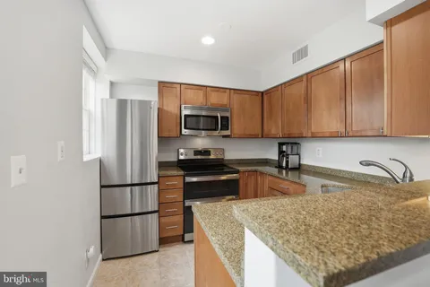a kitchen with granite countertop a refrigerator and a sink