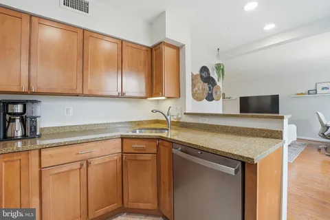 a kitchen with stainless steel appliances granite countertop a sink and a white cabinets