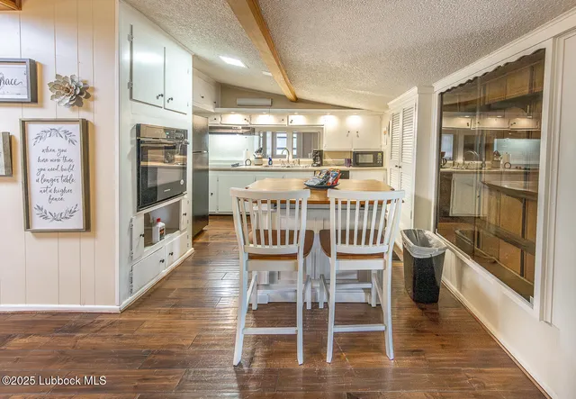 a view of a dining room with furniture a chandelier and wooden floor