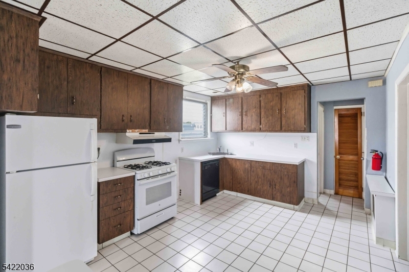 36 Edison Street Bloomfield, NJ 07003 - Photo 4 of 28 a kitchen with a refrigerator a stove top oven and cabinets
