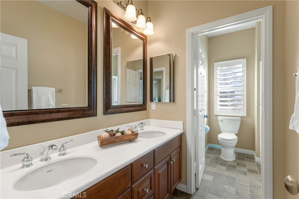 28817 Edenton Way Temecula, CA 92591 - Photo 36 of 56 a bathroom with a double vanity sink toilet and a mirror