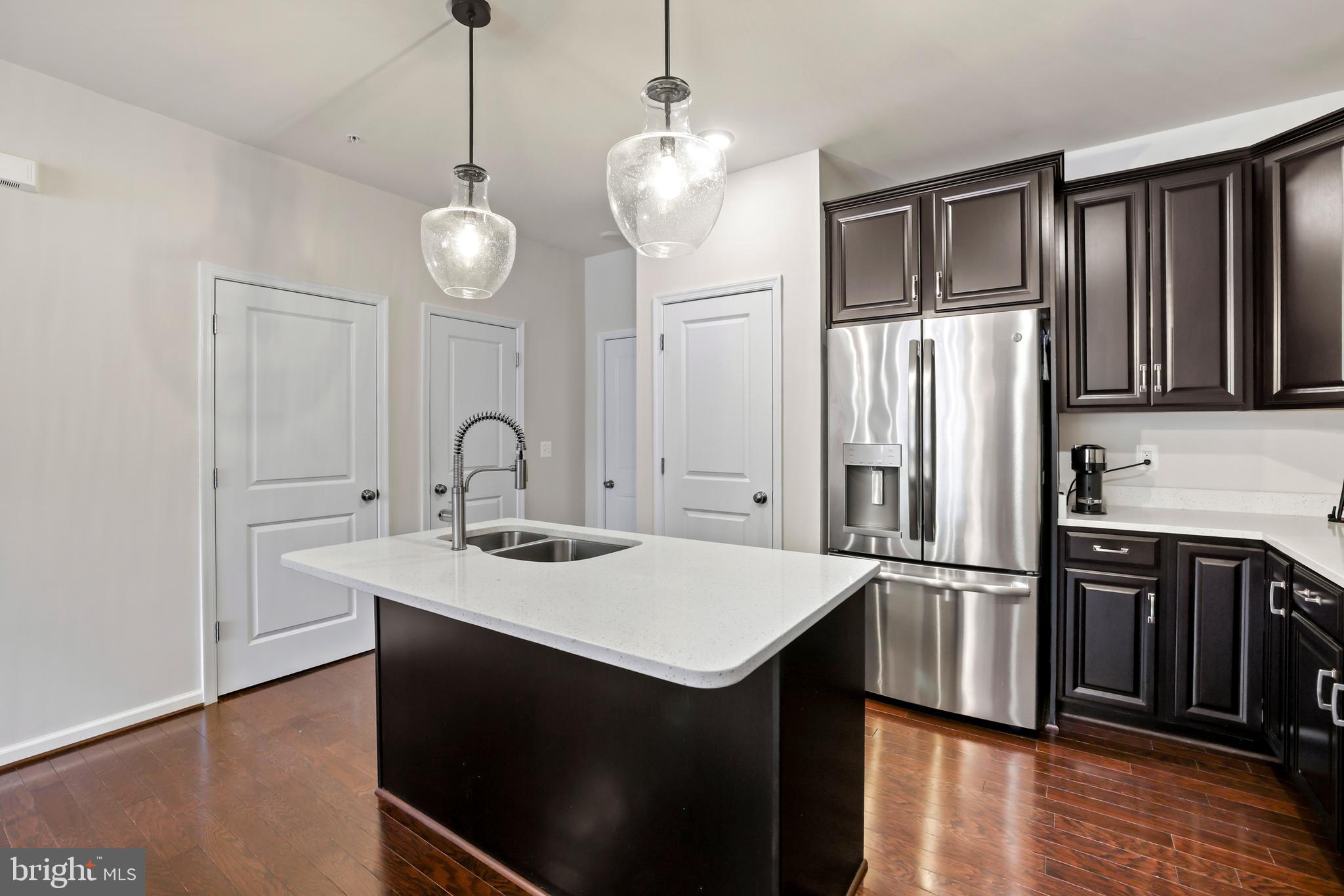 1102 Ribbon Limestone Terrace Southeast Leesburg, VA 20175 - Photo 13 of 51 a kitchen with a sink stainless steel appliances and wooden floor