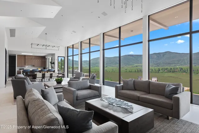 a living room with furniture city view and large windows