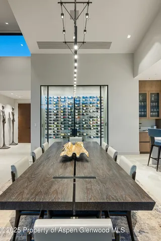 a dining hall with stainless steel appliances granite countertop a sink a stove and chairs