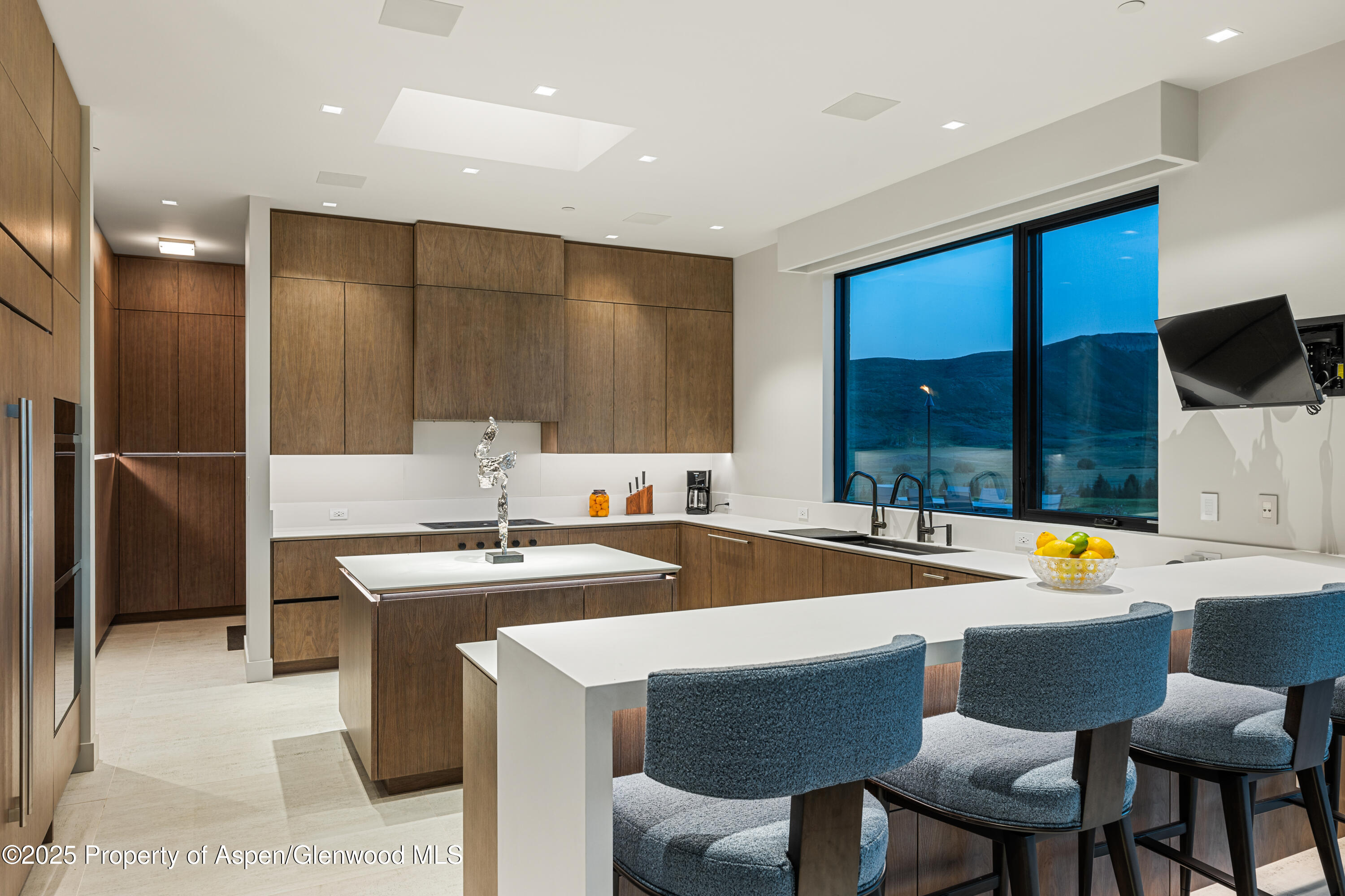 6890 East Sopris Creek Road Snowmass, CO 81654 - Photo 17 of 40 a dining hall with stainless steel appliances granite countertop a sink a stove and chairs