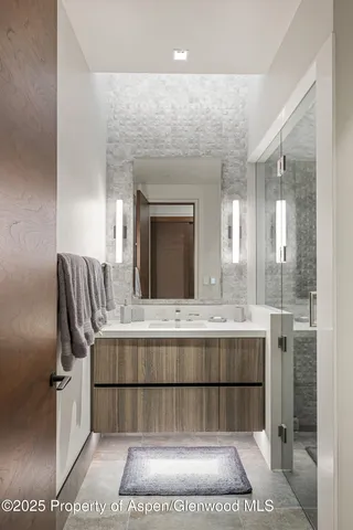 a bathroom with a double vanity sink mirror and shower