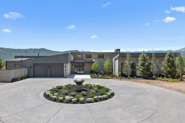 a front view of a house with a yard and potted plants