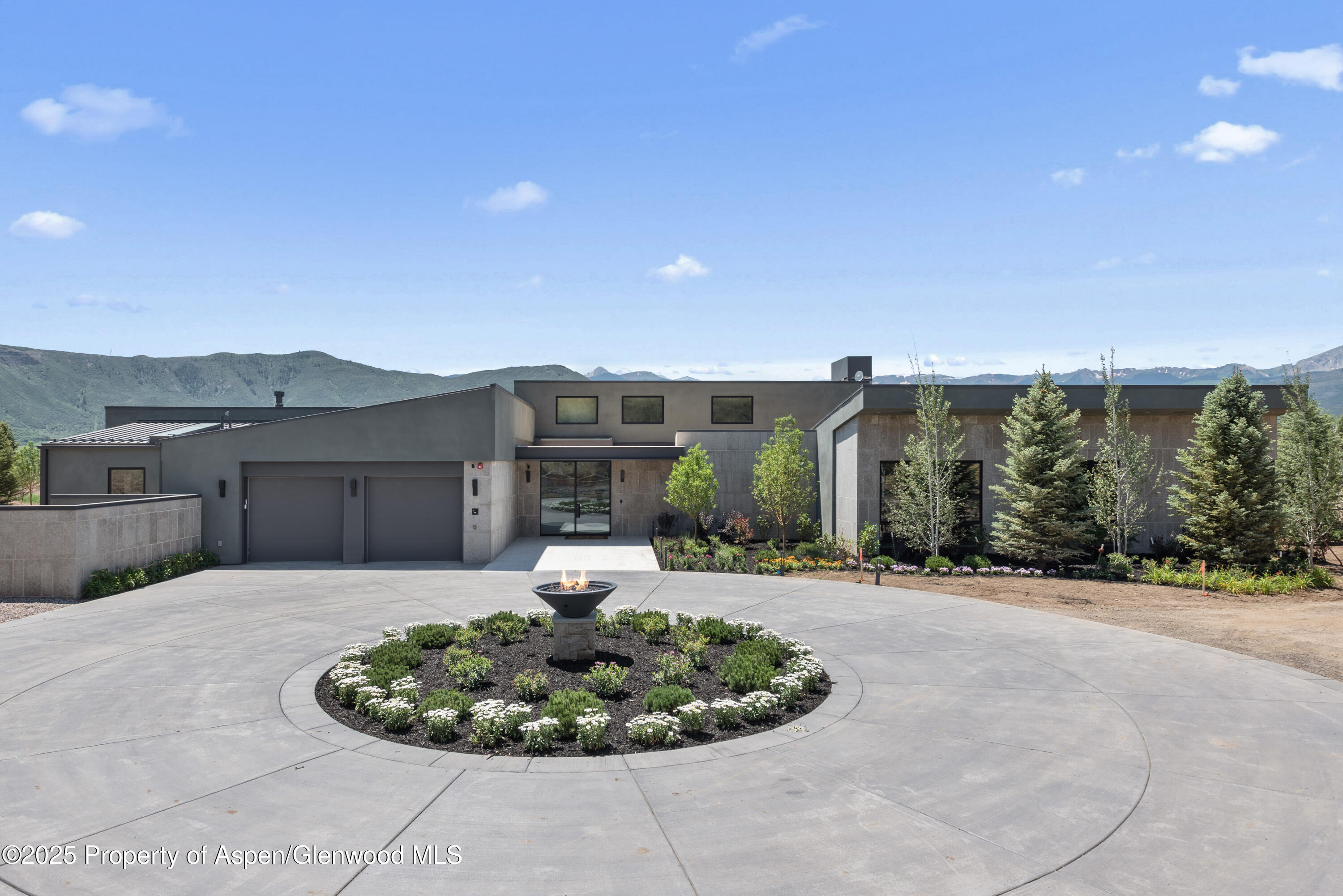 6890 East Sopris Creek Road Snowmass, CO 81654 - Photo 3 of 40 a front view of a house with a yard and potted plants