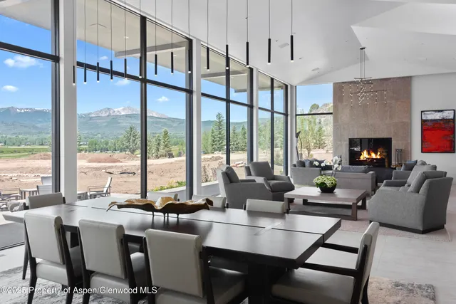 a dining room with furniture a large window and a fireplace