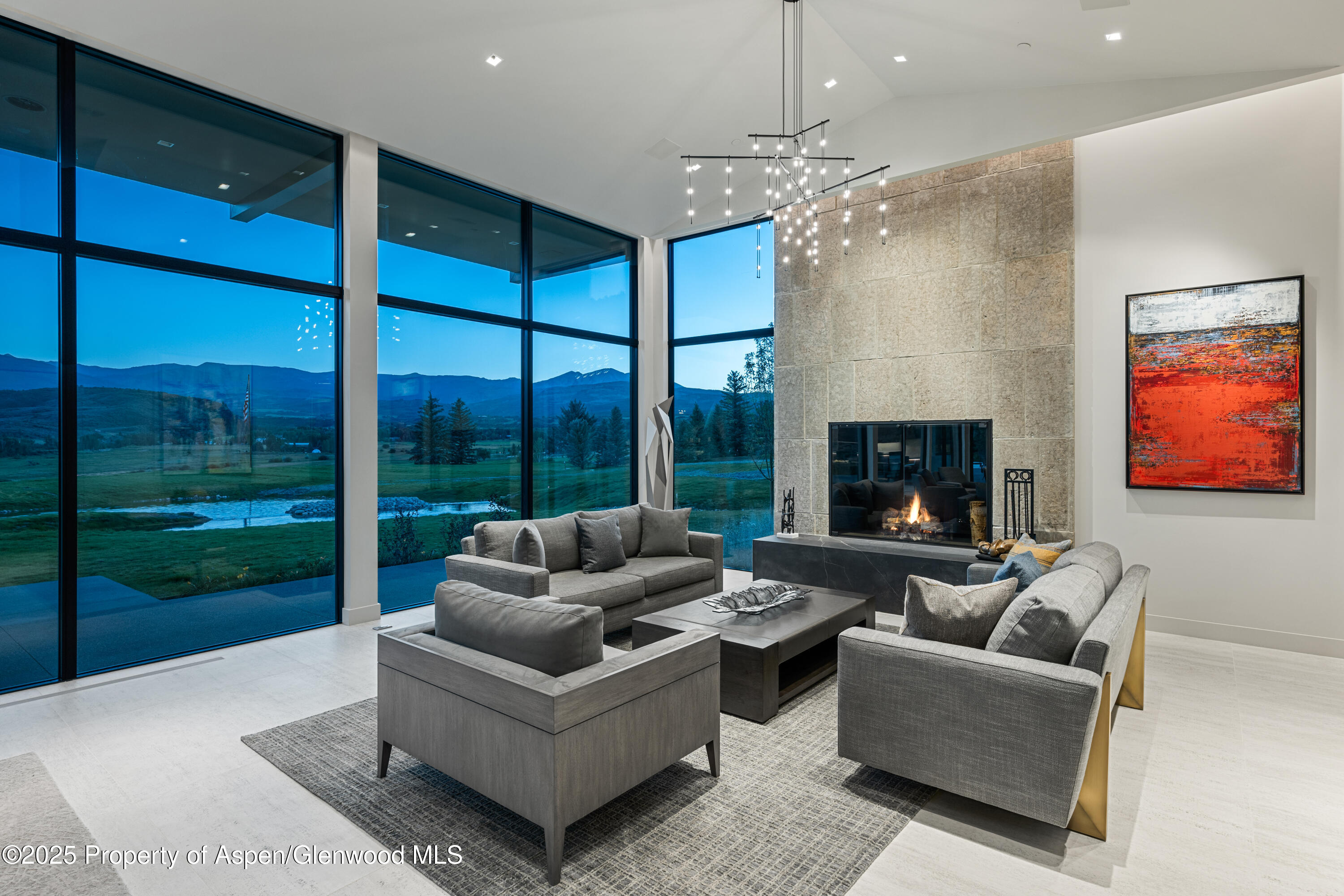 6890 East Sopris Creek Road Snowmass, CO 81654 - Photo 8 of 40 a living room with furniture a chandelier and a fireplace