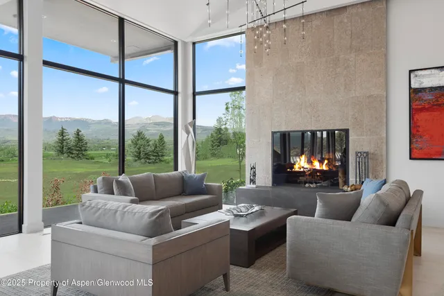 a living room with fireplace furniture and a large window