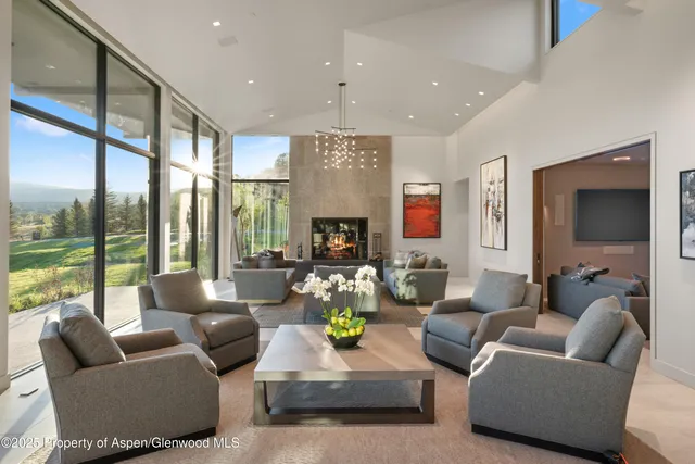 a living room with fireplace furniture and a large window