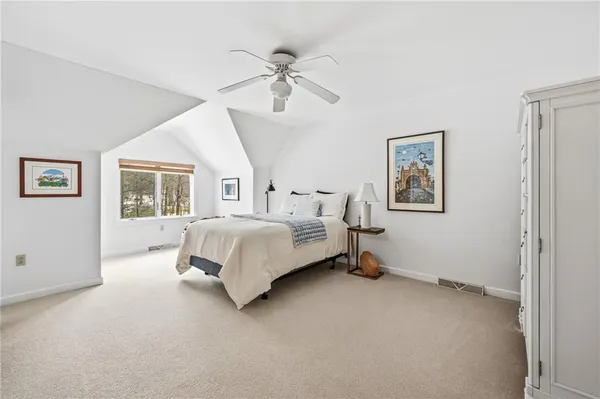 a spacious bedroom with a bed and a chandelier