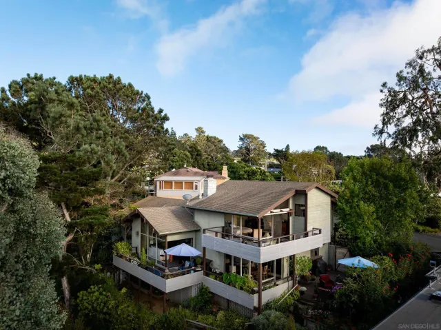 an aerial view of residential houses with outdoor space and trees
