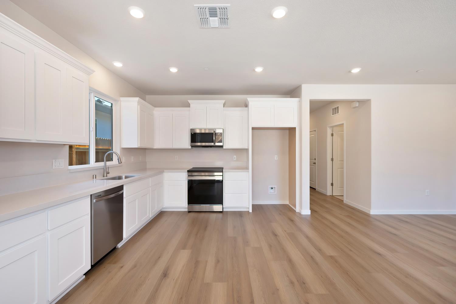 1089 Mallory Ridge Street Roseville, CA 95747 - Photo 12 of 36 a large kitchen with stainless steel appliances granite countertop a lot of cabinets and wooden floor