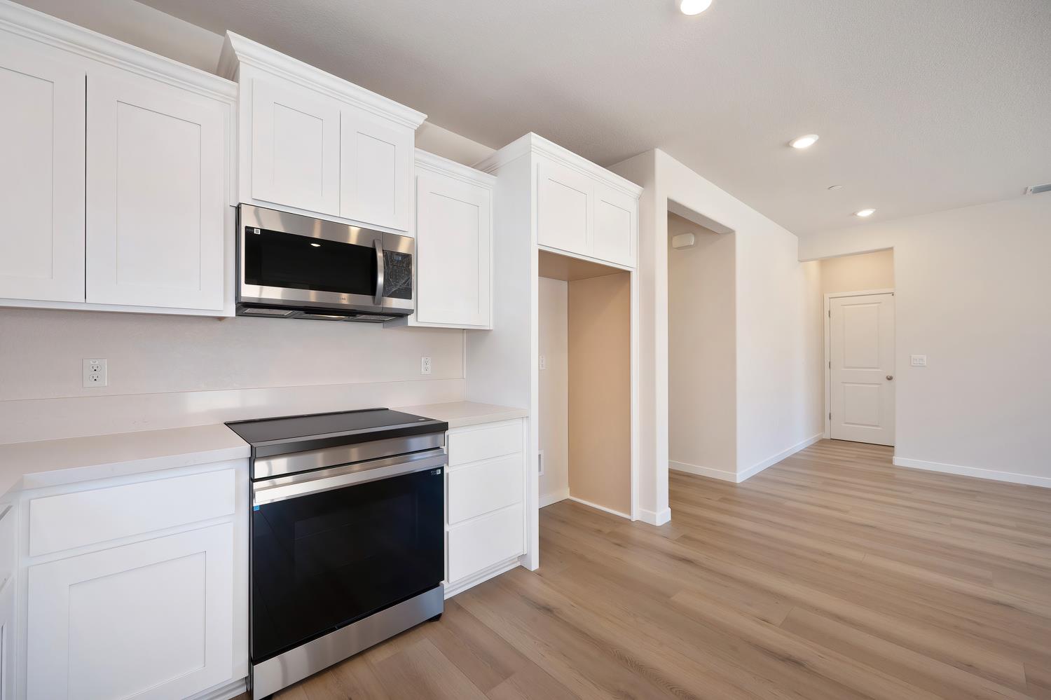 1089 Mallory Ridge Street Roseville, CA 95747 - Photo 8 of 36 a kitchen with stainless steel appliances a stove a microwave and cabinets
