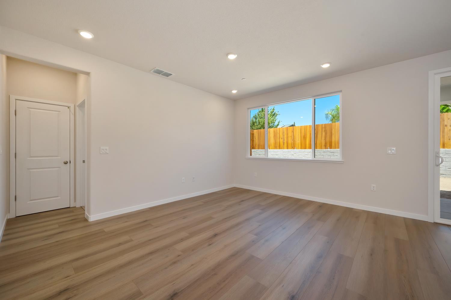 1089 Mallory Ridge Street Roseville, CA 95747 - Photo 9 of 36 an empty room with wooden floor and windows