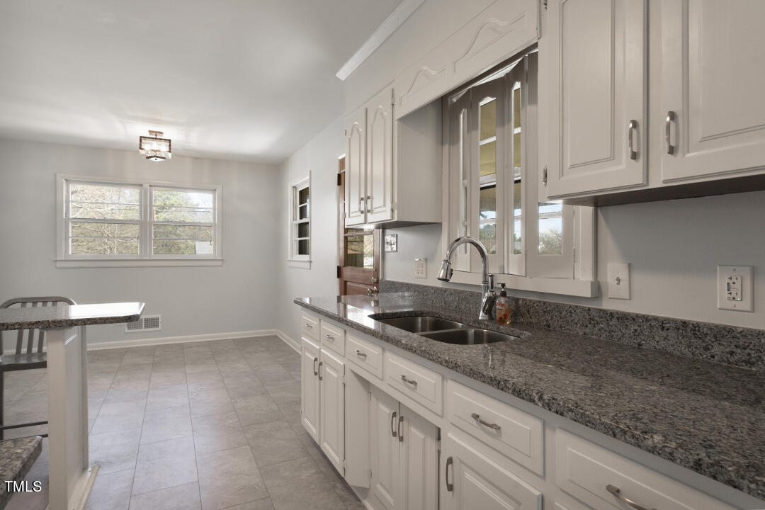 3816 Lee Road Raleigh, NC 27604 - Photo 9 of 32 a kitchen with granite countertop a sink a stove and cabinets