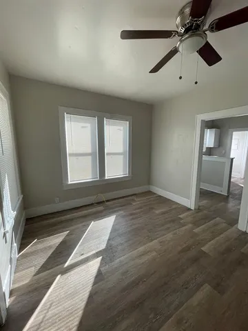 an empty room with windows and fan