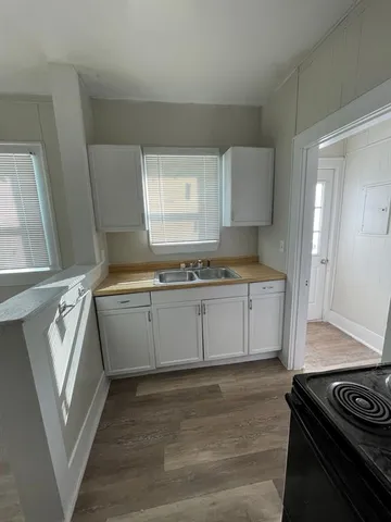 a kitchen with a stove and white cabinets