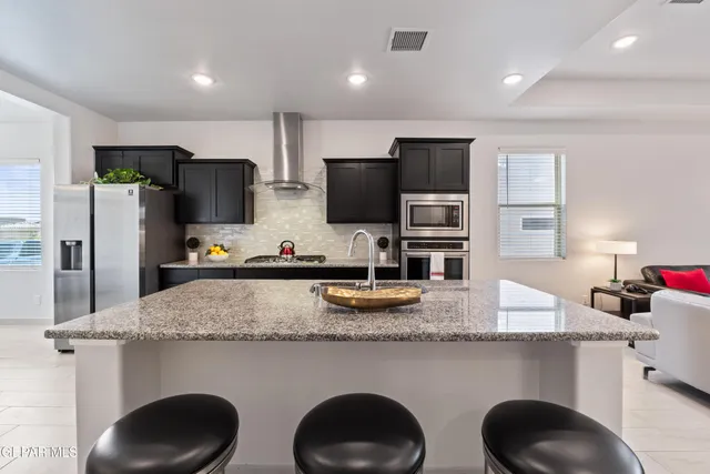 a kitchen with stainless steel appliances granite countertop a sink refrigerator and microwave