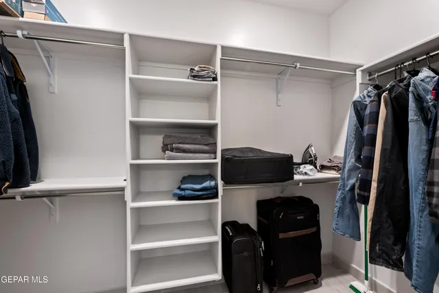 a view of walk in closet with clothes and shoes