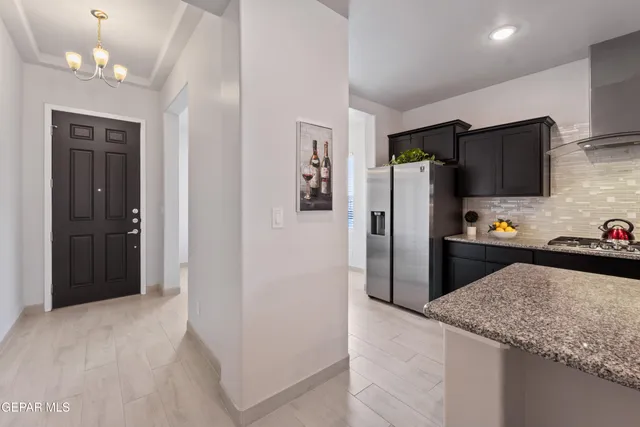 a kitchen with granite countertop a refrigerator and a sink