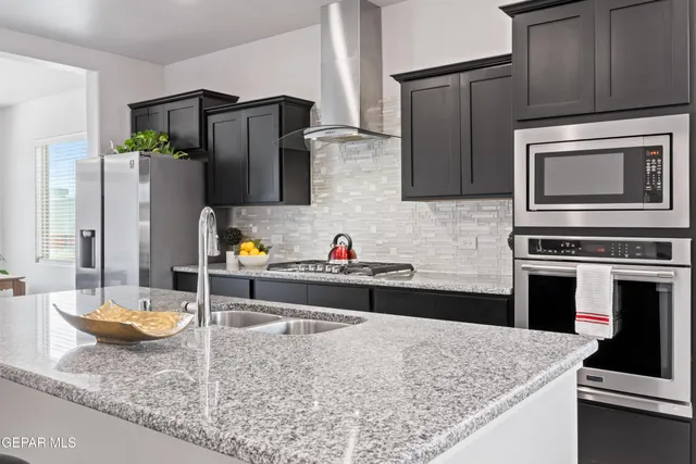 a kitchen with stainless steel appliances granite countertop a sink stove and refrigerator