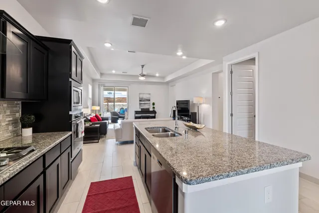 a kitchen with stainless steel appliances granite countertop a sink stove and refrigerator
