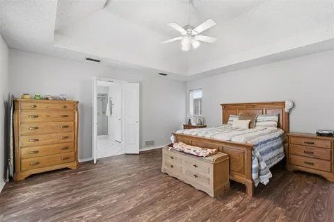 a bedroom with a bed and a ceiling fan