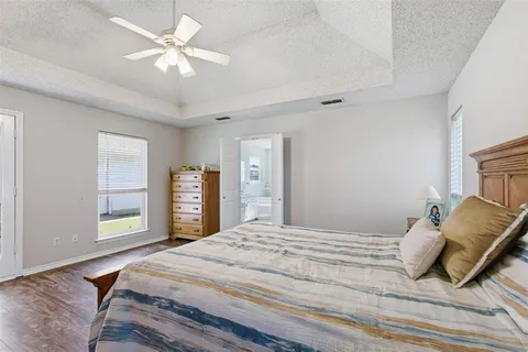a bedroom with a large bed a chandelier and dresser