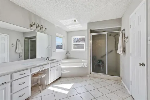 a spacious bathroom with a double vanity sink a mirror and a bathtub