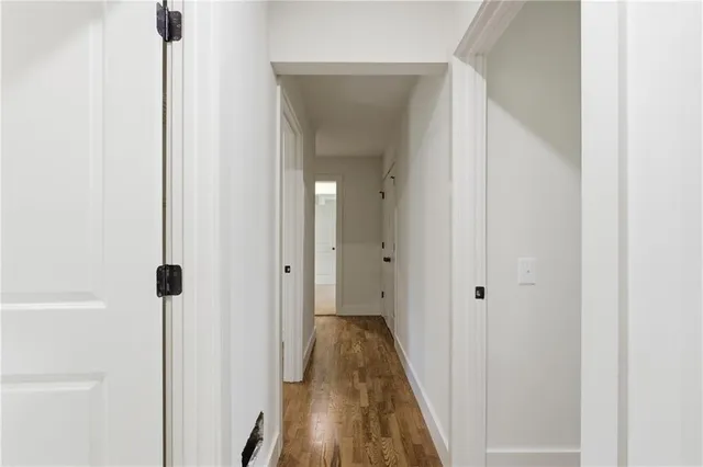 a view of a hallway with wooden floor and staircase