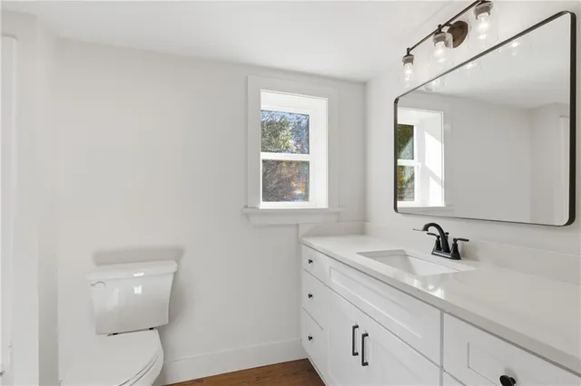a bathroom with a toilet a sink and mirror