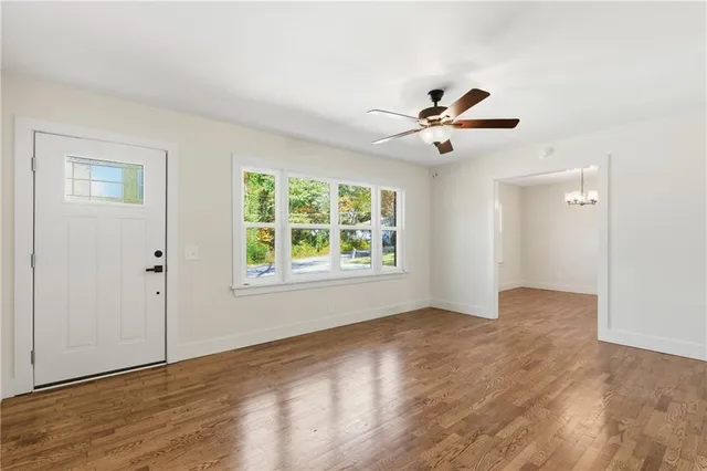 an empty room with fan and windows