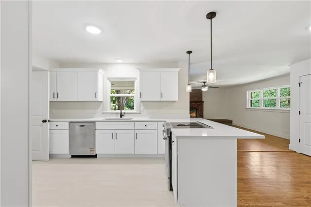 a kitchen filled with white cabinets appliances and a window