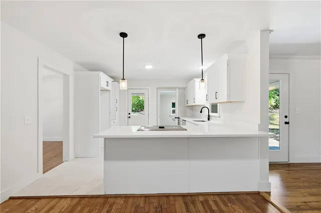 a kitchen with kitchen island a sink a counter top space and cabinets