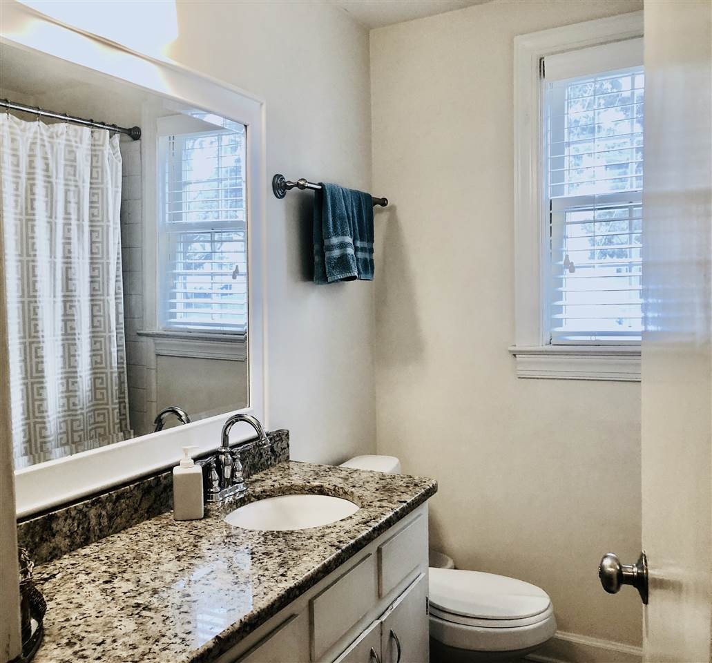 1607 Sutton Drive Raleigh, NC 27605 - Photo 18 of 24 Hall bath with tub/shower, white ceramic bath wall, granite countertop Bathroom