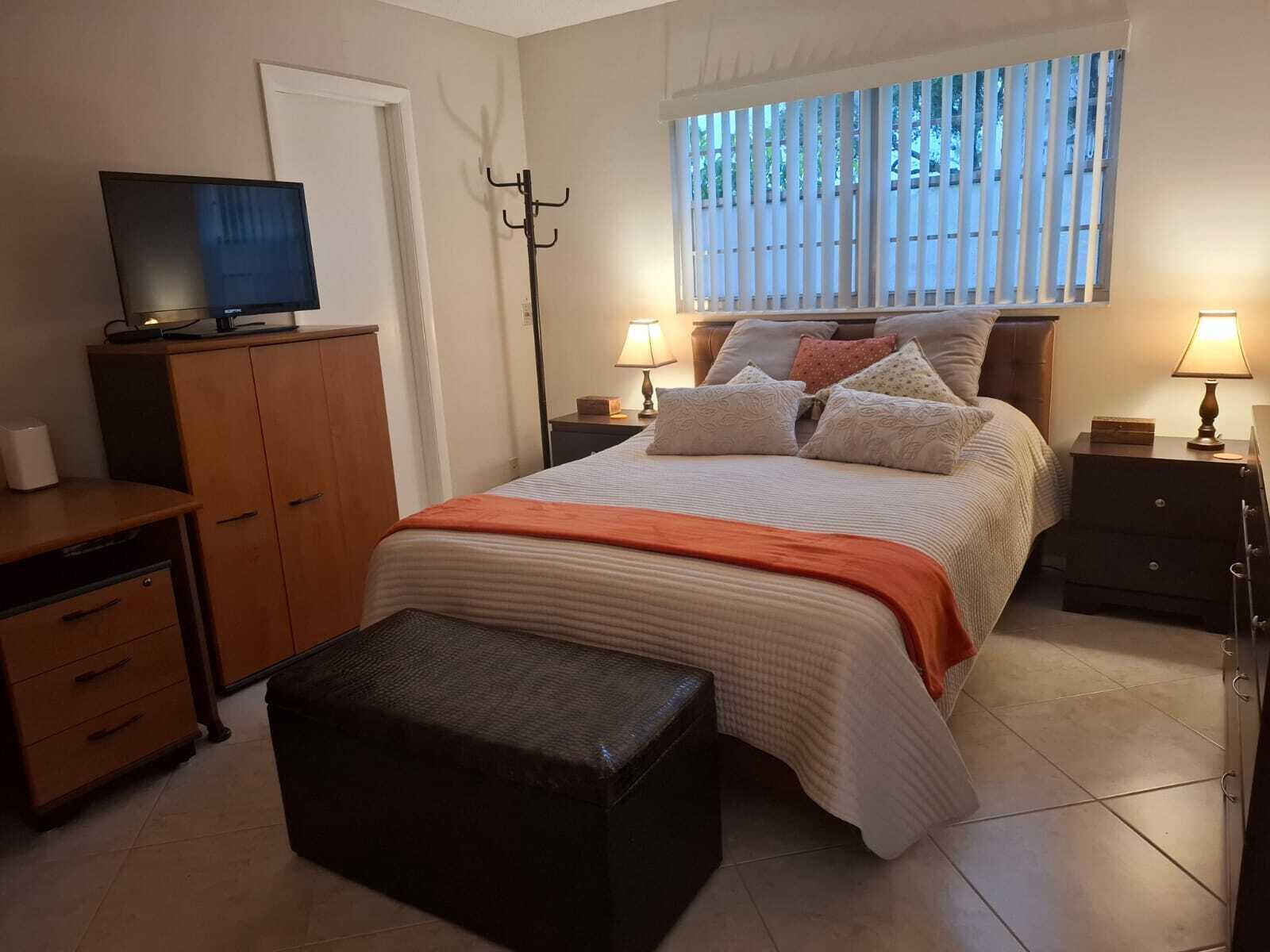 30 Oakridge C, Unit 30 Deerfield Beach, FL 33442 - Photo 8 of 12 a bedroom with a bed flat screen tv and a closet