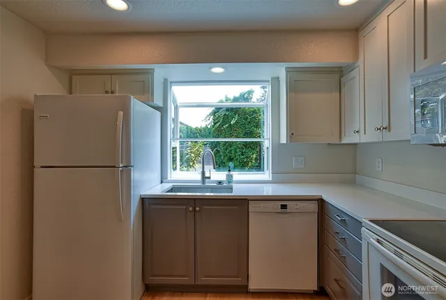 a kitchen with stainless steel appliances a refrigerator sink and cabinets