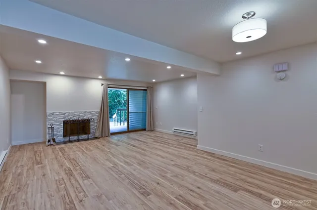 an empty room with windows and fireplace