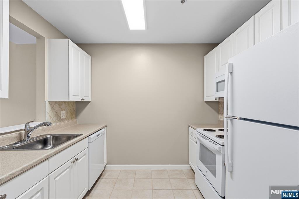 905 River Road, Unit 307 Edgewater, NJ 07020 - Photo 14 of 34 a kitchen with a sink cabinets and stainless steel appliances