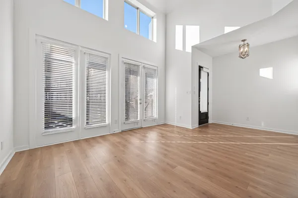 a view of an empty room with a kitchen and entryway