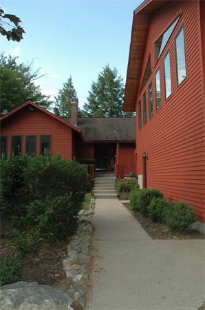 21 Island Road Ashburnham, MA 01430 - Photo 4 of 27 a view of a brick house with a yard and large trees