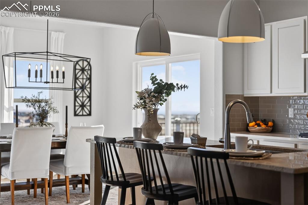 12955 Sunrise Ridge Drive Peyton, CO 80831 - Photo 5 of 49 a kitchen with stainless steel appliances a table chairs and a refrigerator
